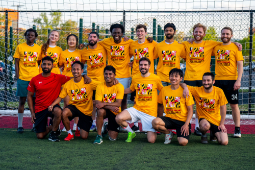 An intramural sports soccer team poses in front of the goal wearing their UMD Intramural Champion t-shirts