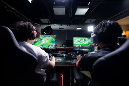 two people with their backs to the camera participating in esports