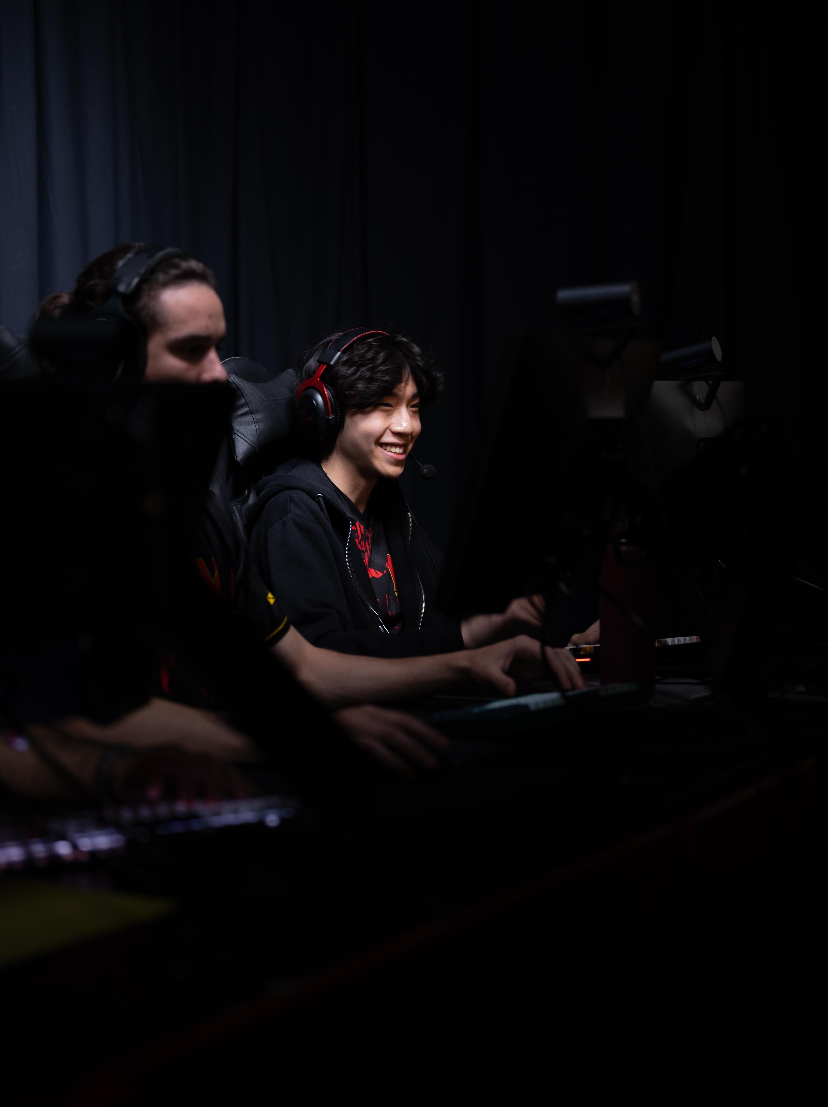 Terps Esports Player smiling at his computer screen.