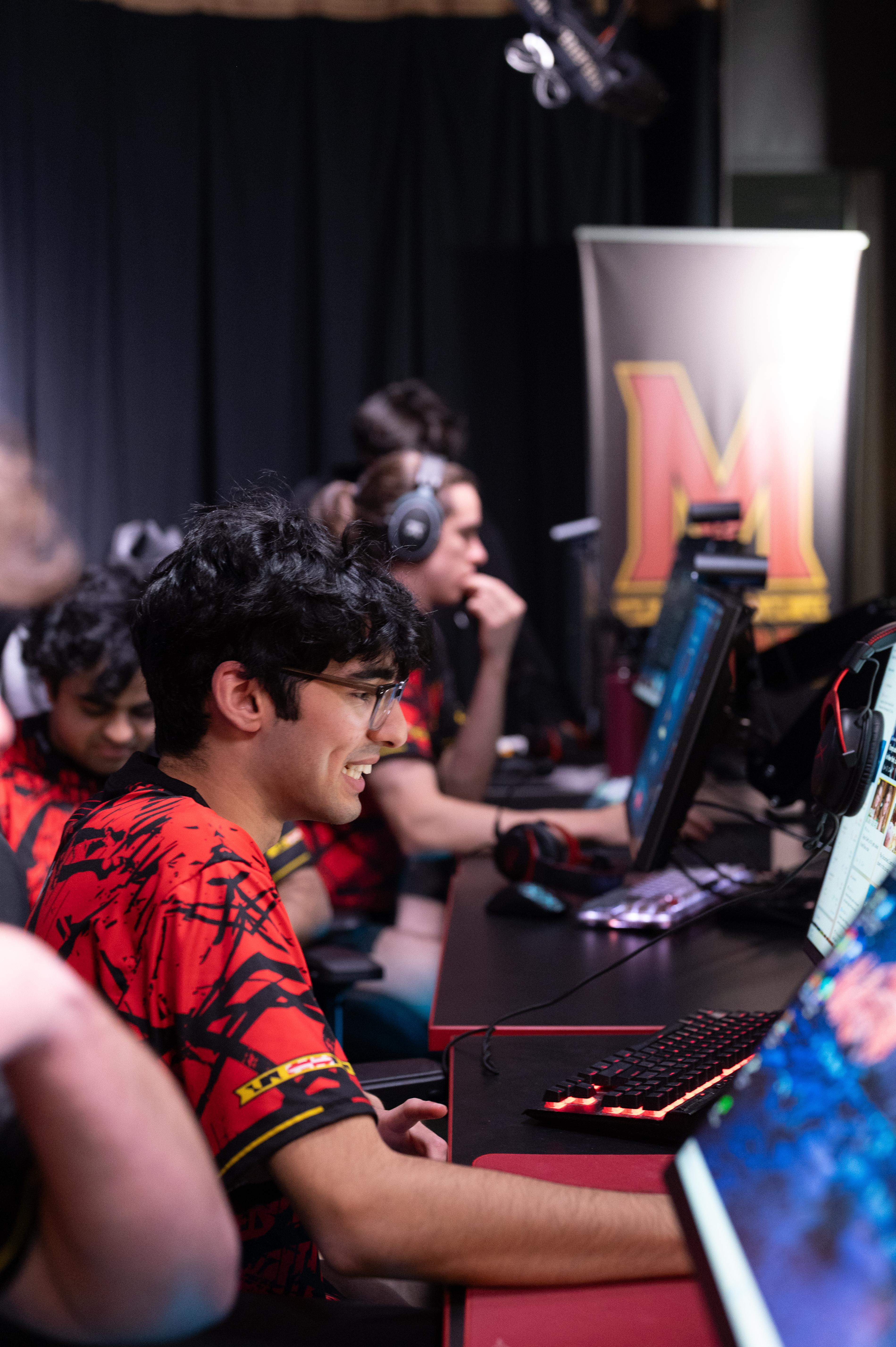 Terps Esports Player smiling at his computer screen.